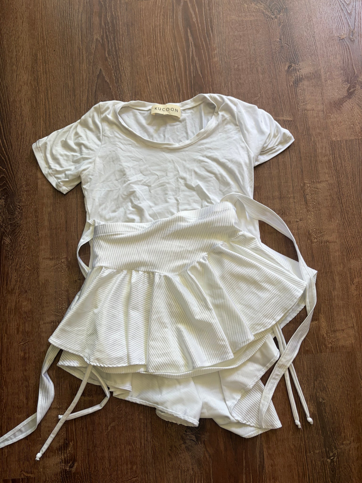 White dress with ribbons on a wooden surface