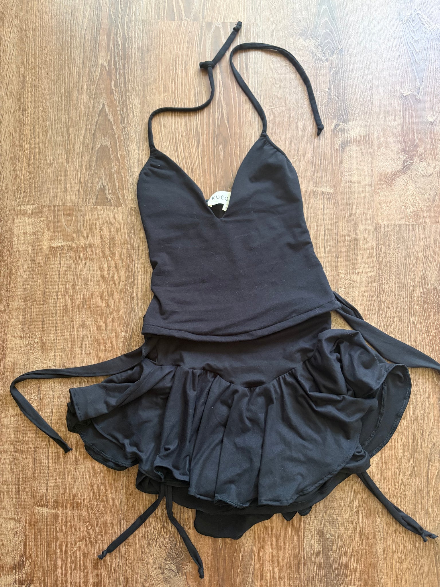Black bikini top with ruffled details on a wooden surface