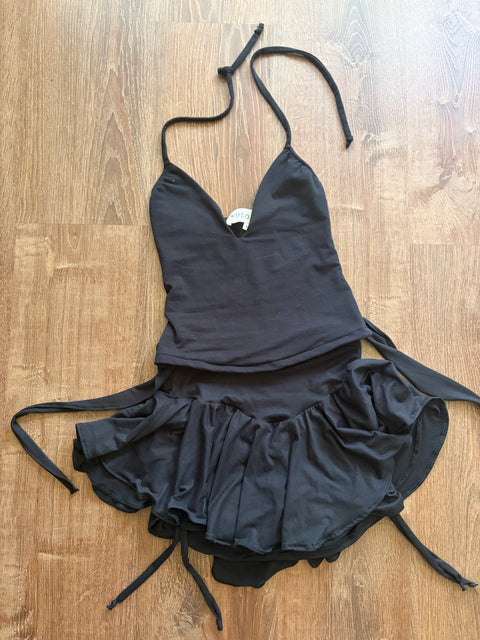 Black bikini top with ruffled details on a wooden surface
